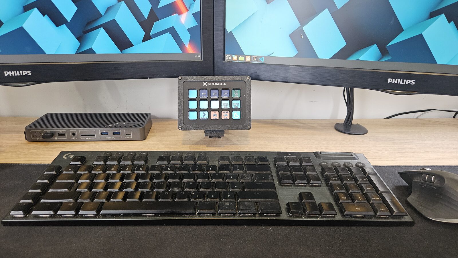 El Stream Deck montado entre los dos monitores, ahí viven los dos botones de Claude.